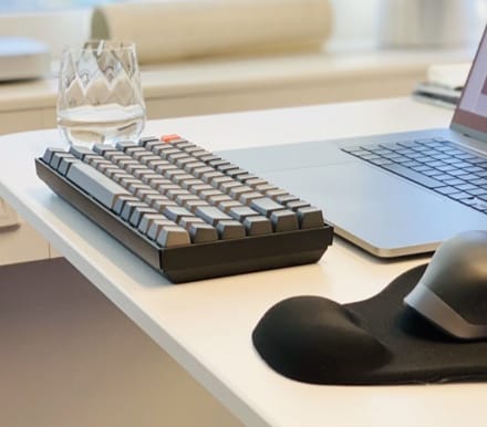 keyboard and drinking glass on a desk